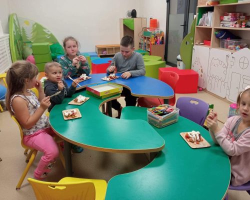 Dzieci siedzące przy dziecięcym stoliku